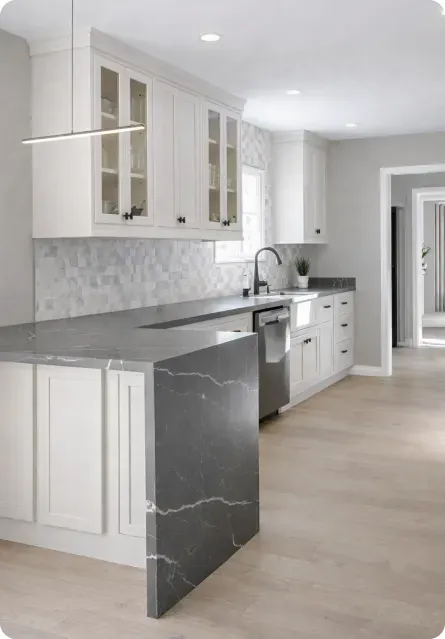 White shaker kitchen with gray quartz waterfall island and marble backsplash